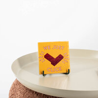 Keramieken tegeltje met LEGO-ontwerp en tekst We Just Click op display